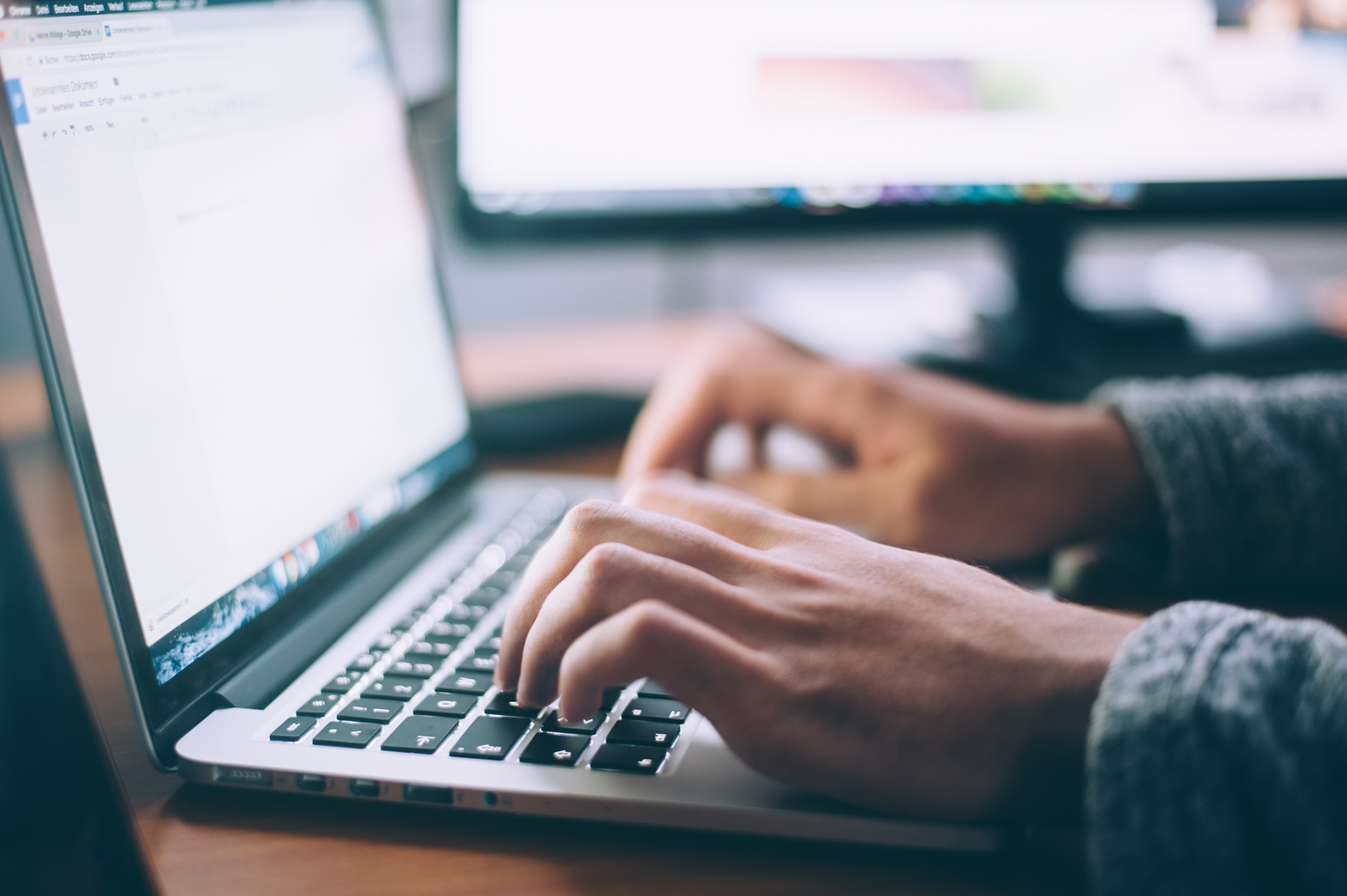 A software developer typing code on a laptop